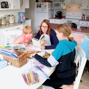 mom and kids homeschooling at the kitchen table